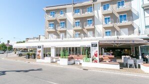 A hotel with multiple balconies, outdoor seating, and a restaurant named 'Ghost Wine'. - Hotel Colonna (Jesolo)