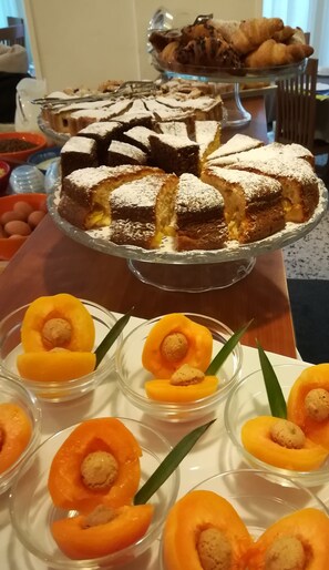 A dessert table with various pastries and a cake.