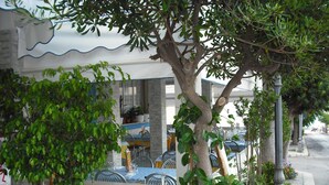 Un restaurant doté d’une terrasse, d’une façade en pierre et de plantes en pot.