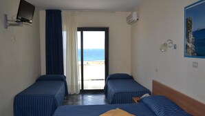 Une chambre d’hôtel avec deux lits, une télévision, la climatisation et une vue sur la mer.