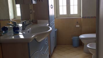 A bathroom with a sink, mirror, and toilet.