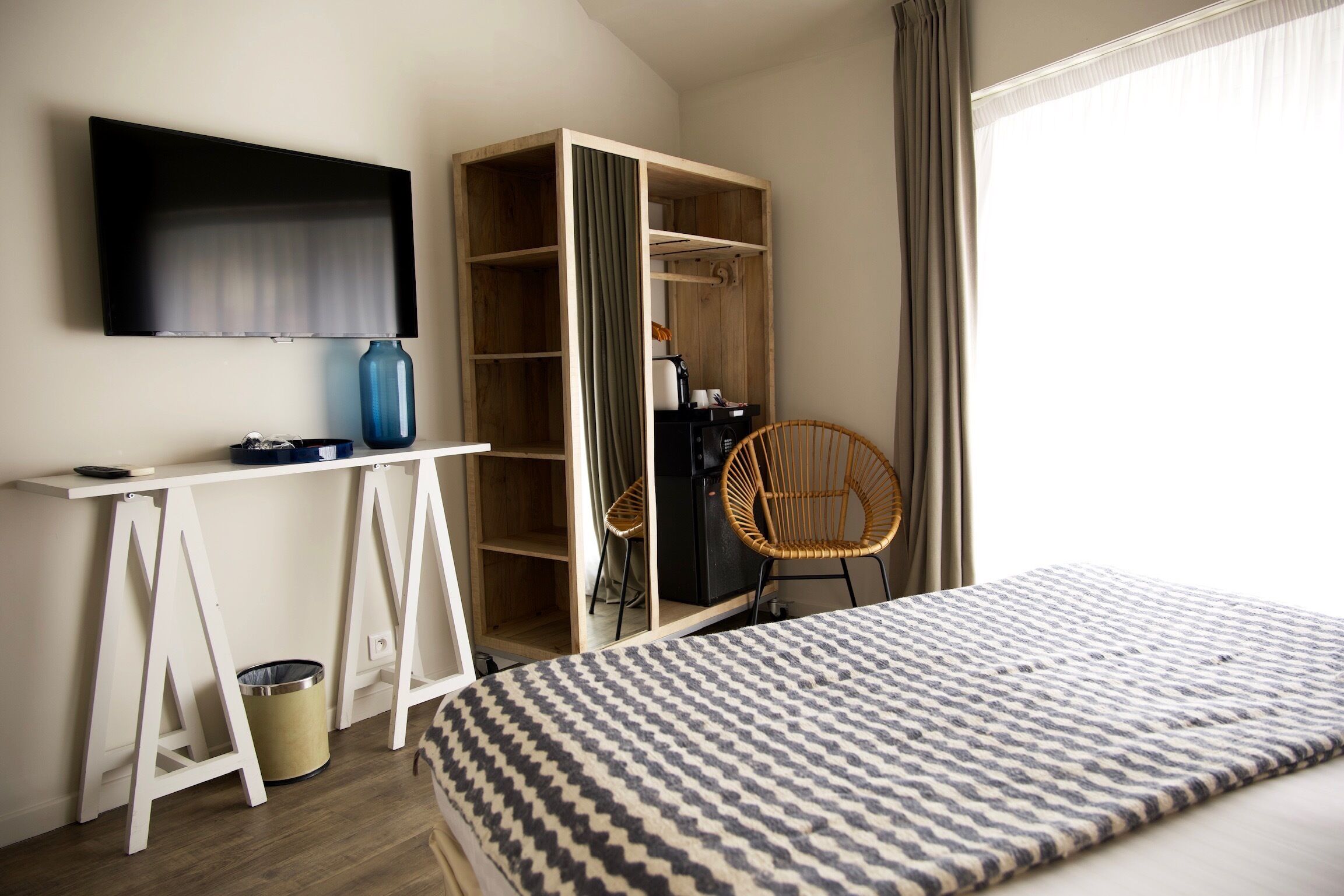 Een slaapkamer met een bed, bureau, kledingkast, televisie en een stoel.