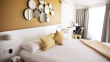 Une chambre d’hôtel avec un grand lit, plusieurs oreillers, un bureau et une chaise.