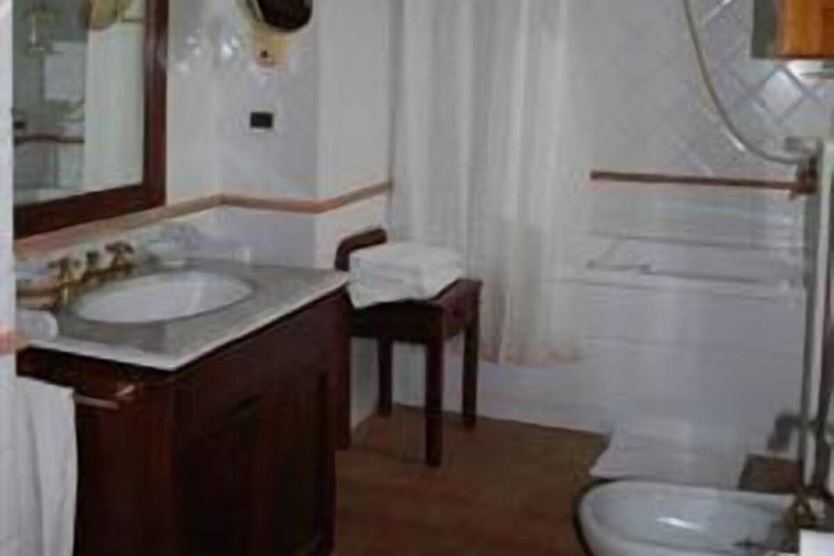 Ein Badezimmer mit Waschbecken, Spiegel und zwei Toiletten.