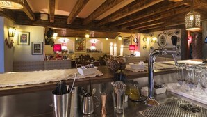 A bar area with a wooden ceiling, bar stools, a bar counter, and various bar tools. - Hotel Cir (Corvara in Badia)