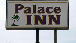Letrero de un hotel llamado 'Palace Inn' con un icono de palmera.