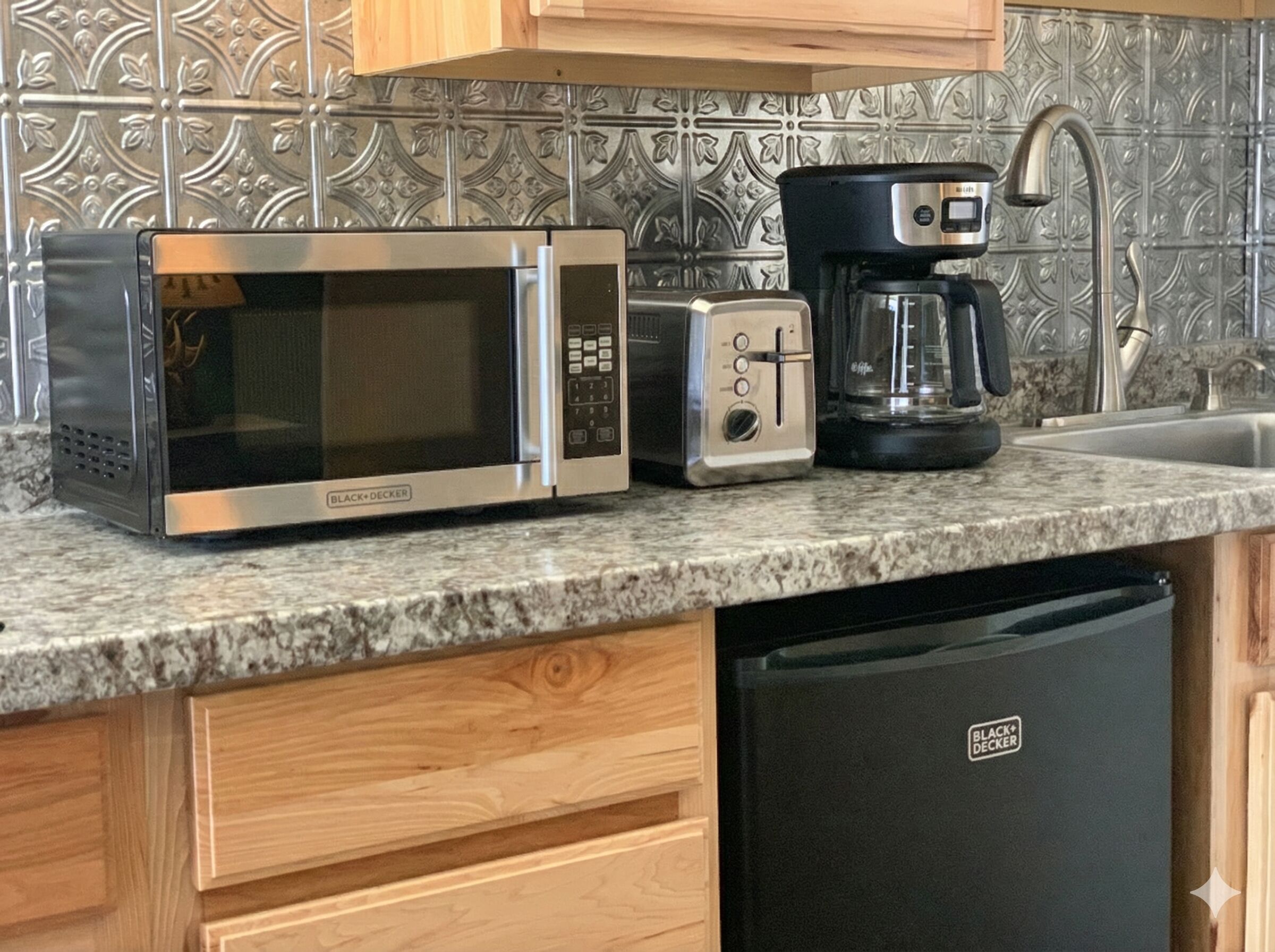 A kitchen with a microwave, toaster, coffee maker, and dishwasher.
