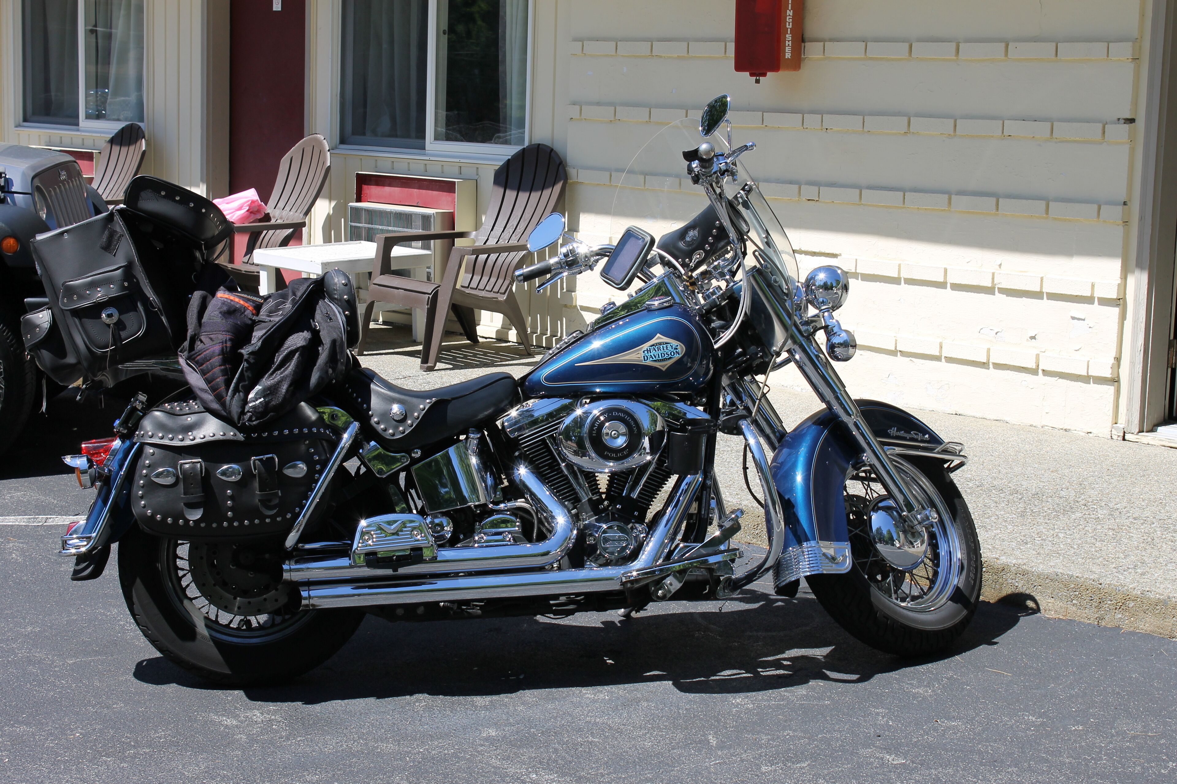 A motorcycle parked outside a building with a brick facade, a window, and a door.