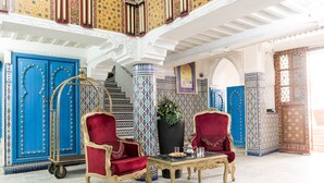 A luxurious interior with ornate blue doors, a grand staircase, and elegant furniture. - Moroccan House Hotel Casablanca (Casablanca)