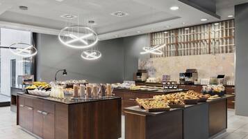 A modern breakfast bar with a variety of food items and a coffee station.