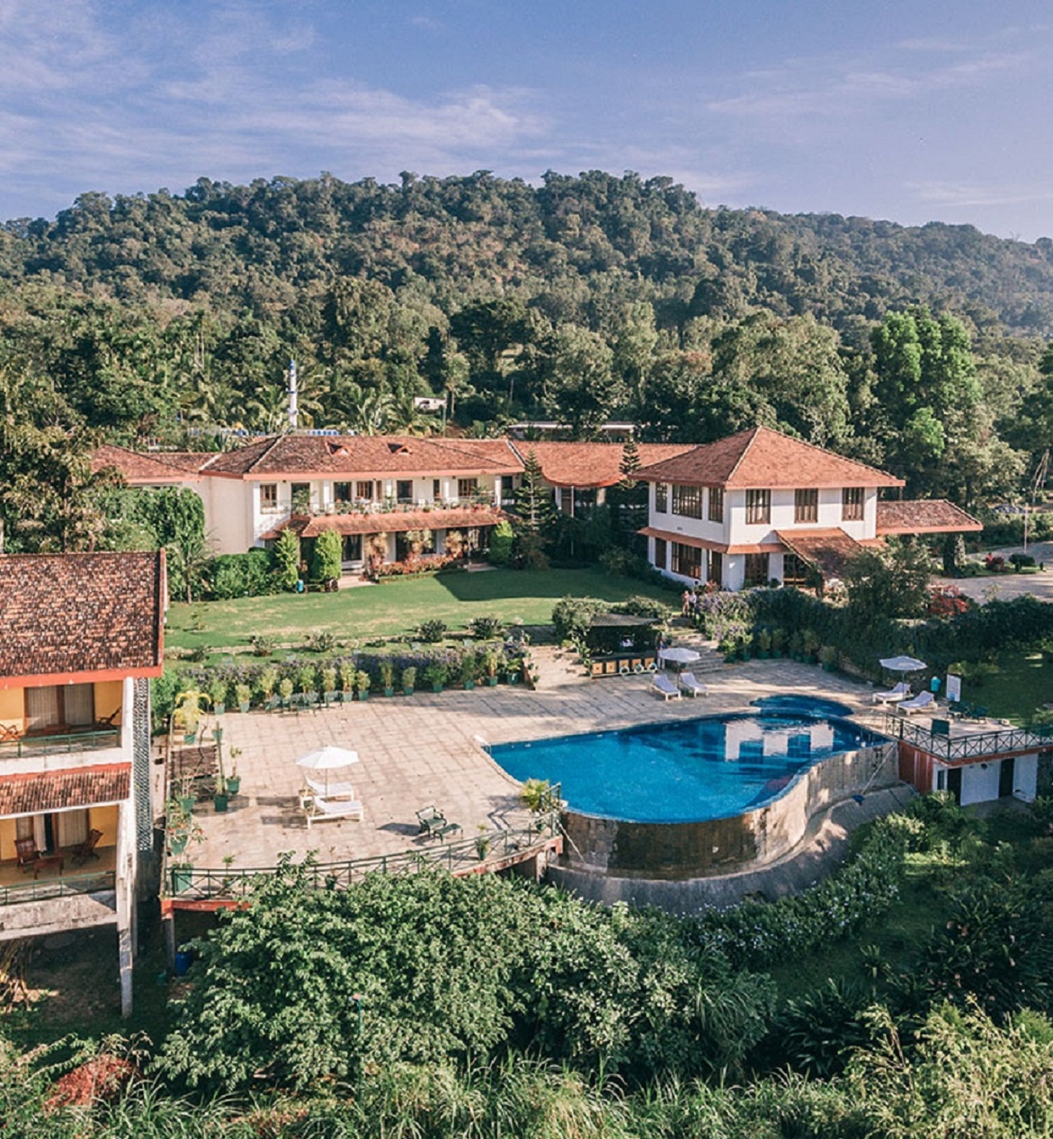 Ein großes, zweistöckiges Haus mit Swimmingpool und einem gepflegten Garten.