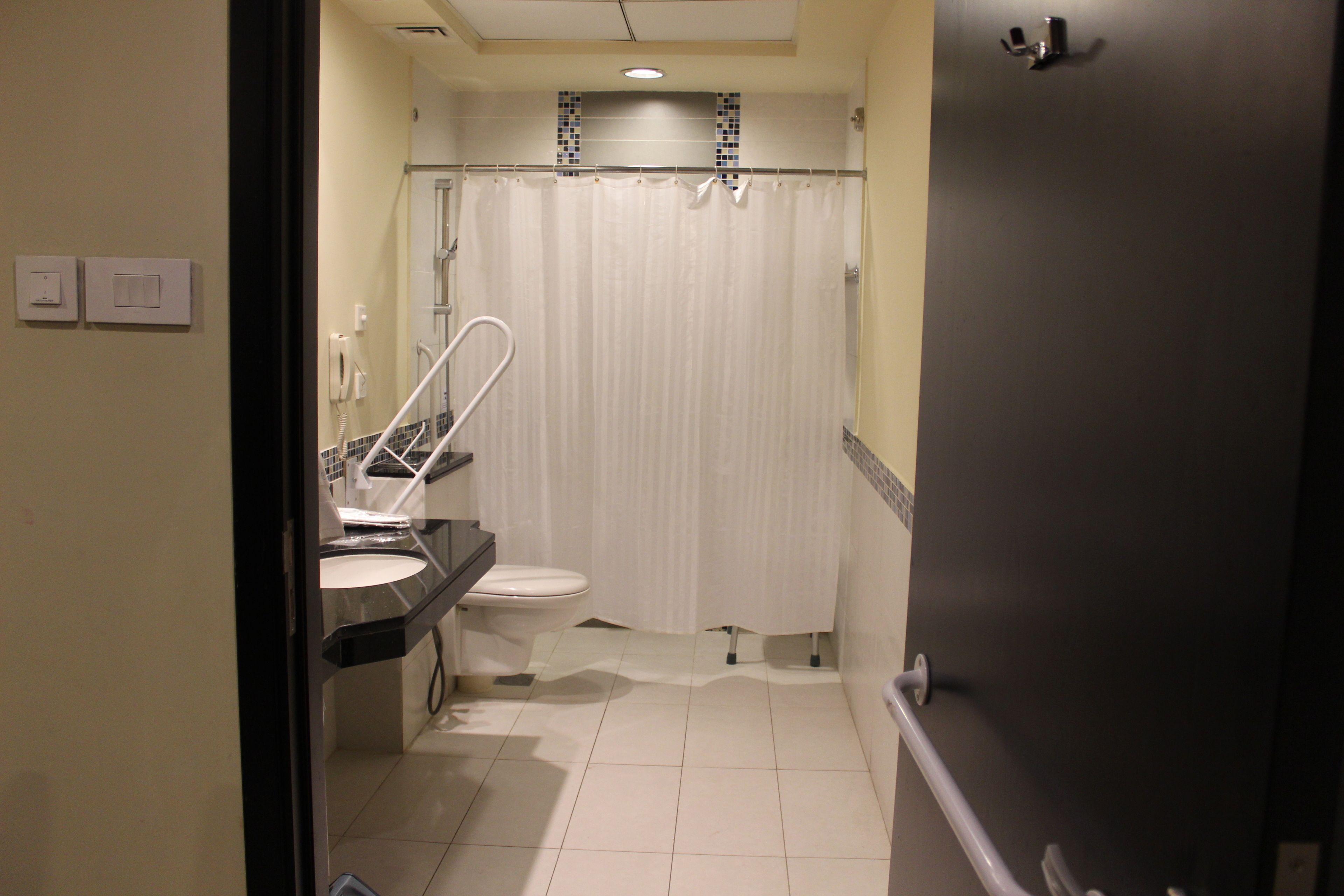 Een badkamer met toilet, wastafel en douchegordijn.