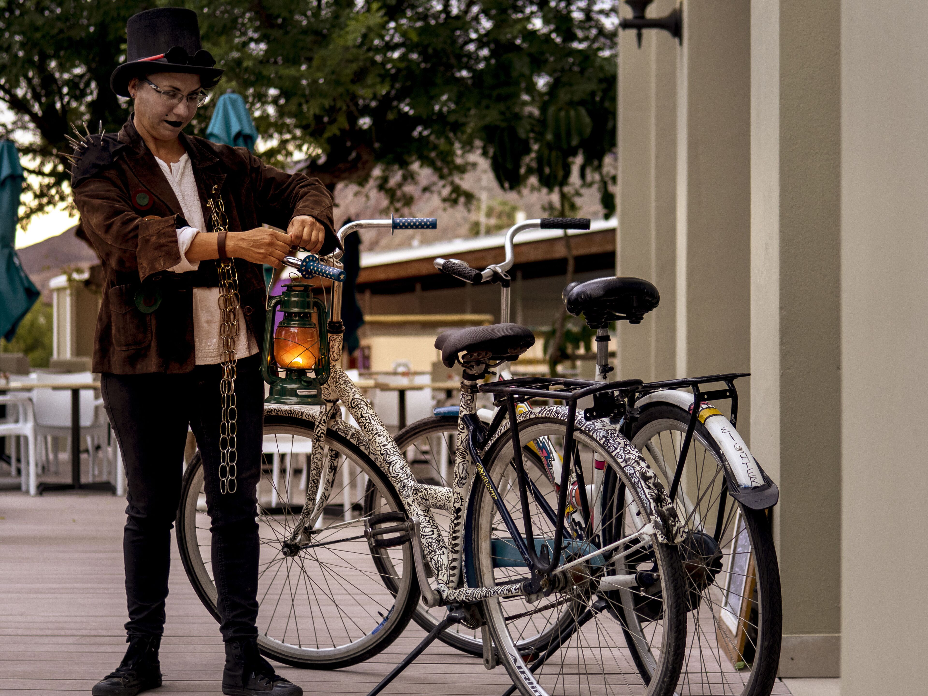 A person standing next to a bicycle with a lantern attached to it.