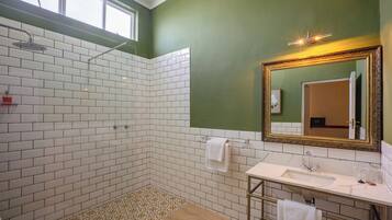 A bathroom with a shower, a sink, and a mirror.