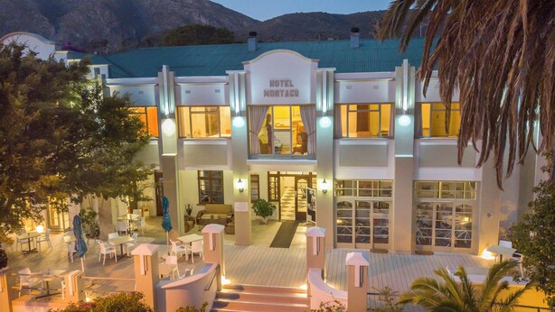 Un hôtel au design moderne, doté d’une entrée imposante, d’un espace extérieur aménagé et offrant une vue sur le paysage environnant.