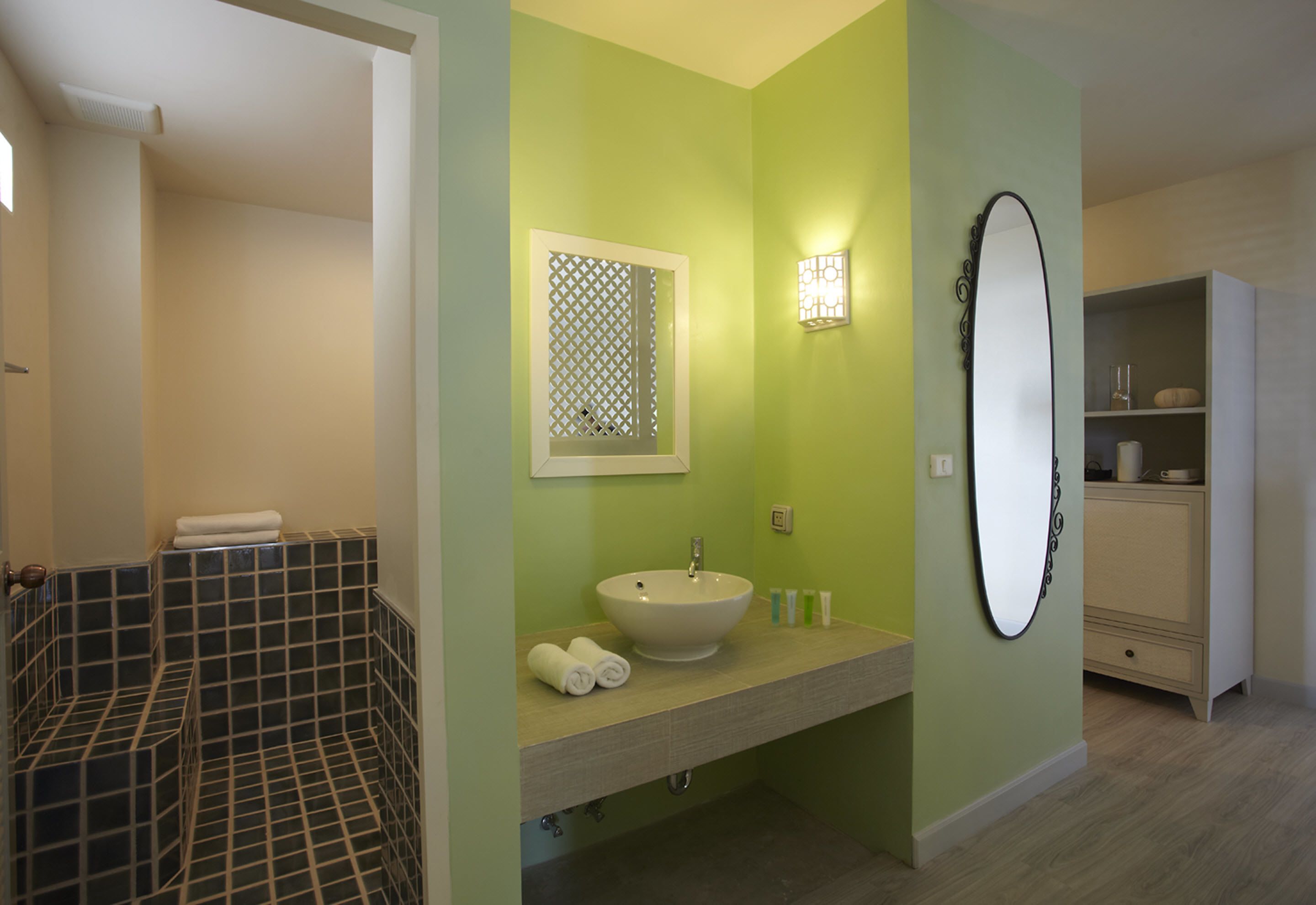 Un baño con lavamanos blanco, espejo e inodoro.