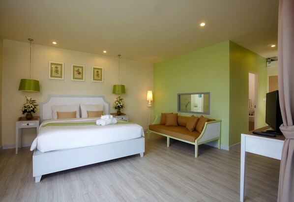 Une chambre moderne avec un grand lit, un canapé, une télévision et un bureau.