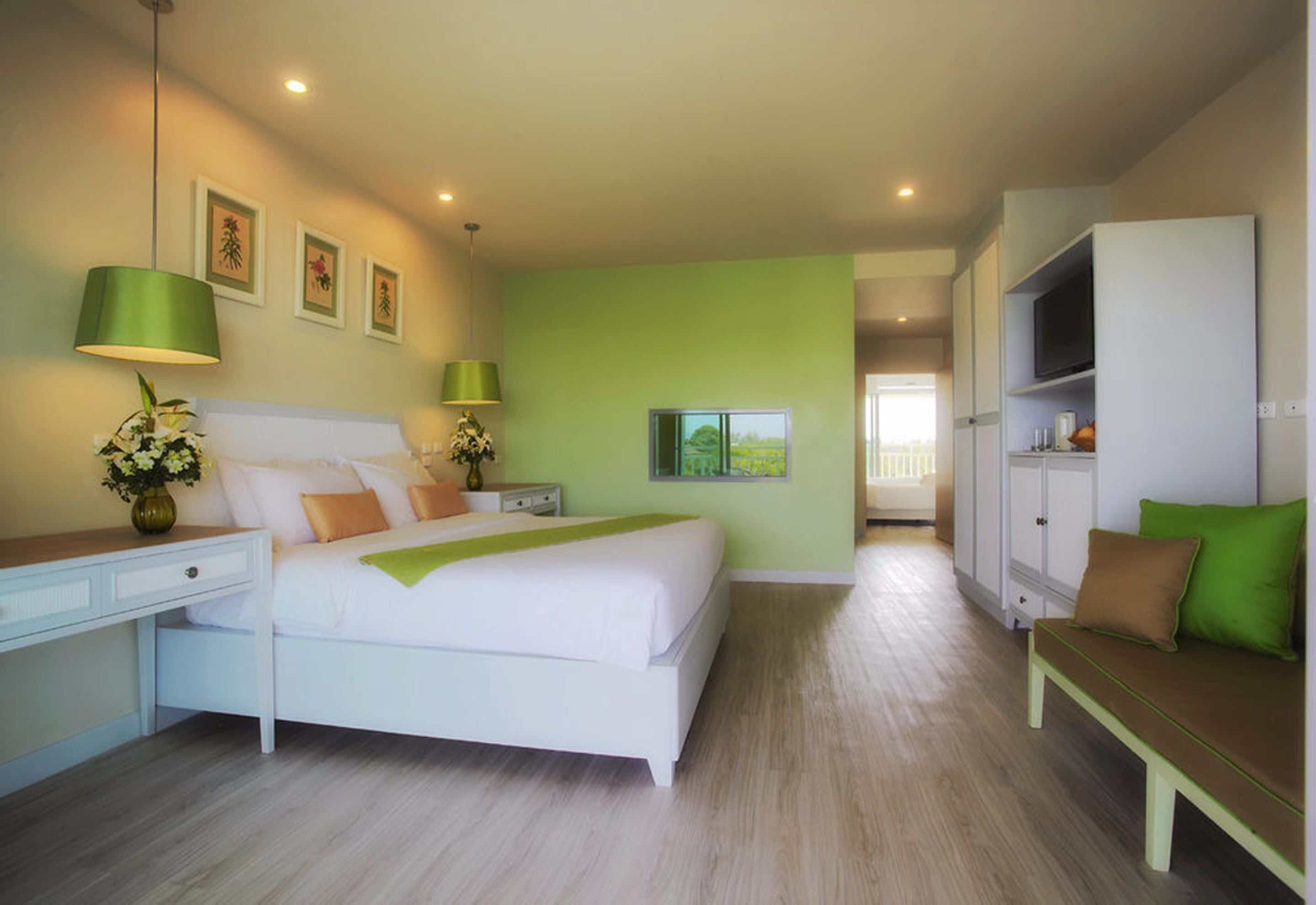 A modern bedroom with a bed, bedside tables, a desk, a TV, and a sofa.