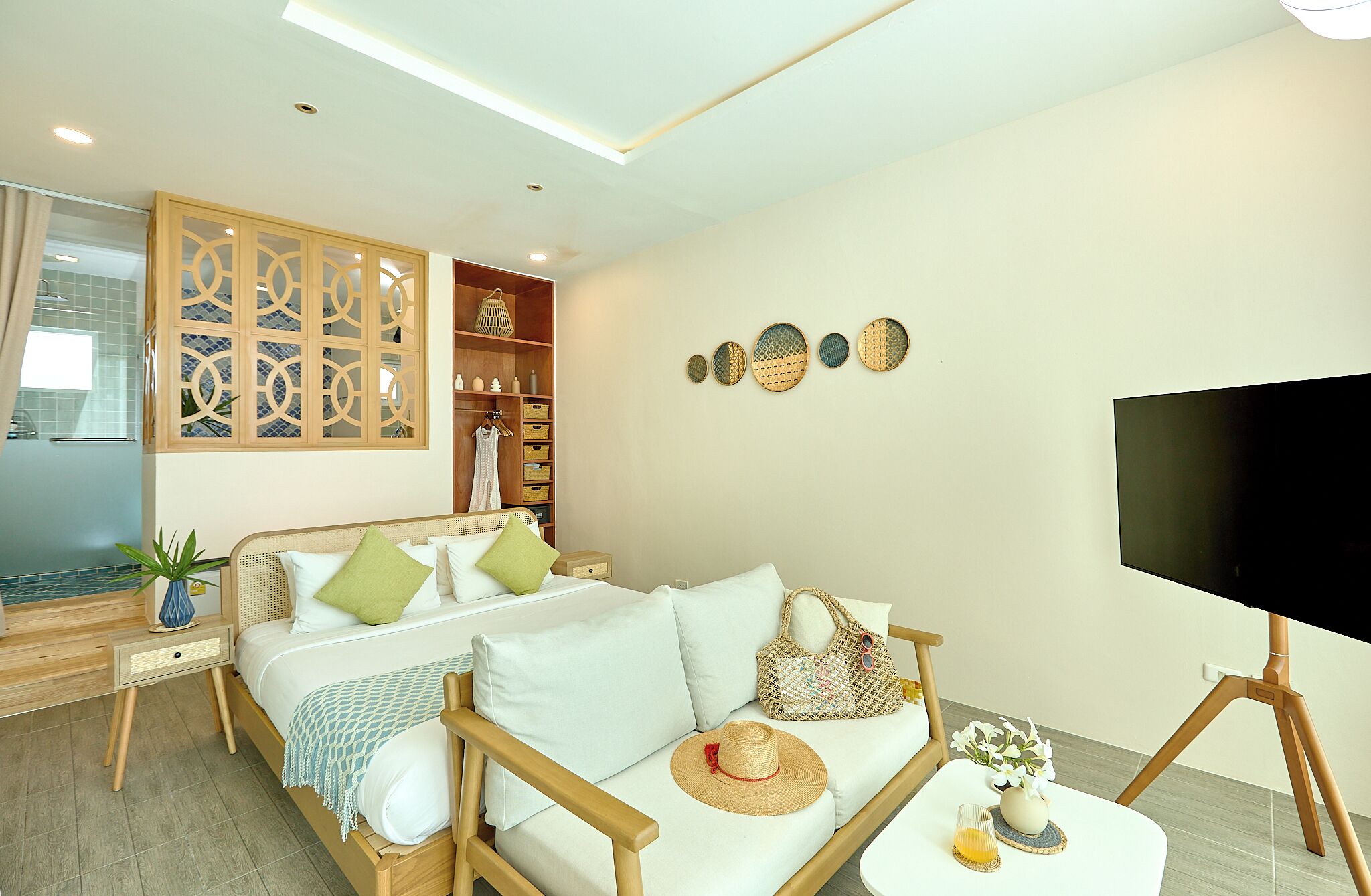 A modern bedroom with a bed, a sofa, a TV, and a wardrobe.