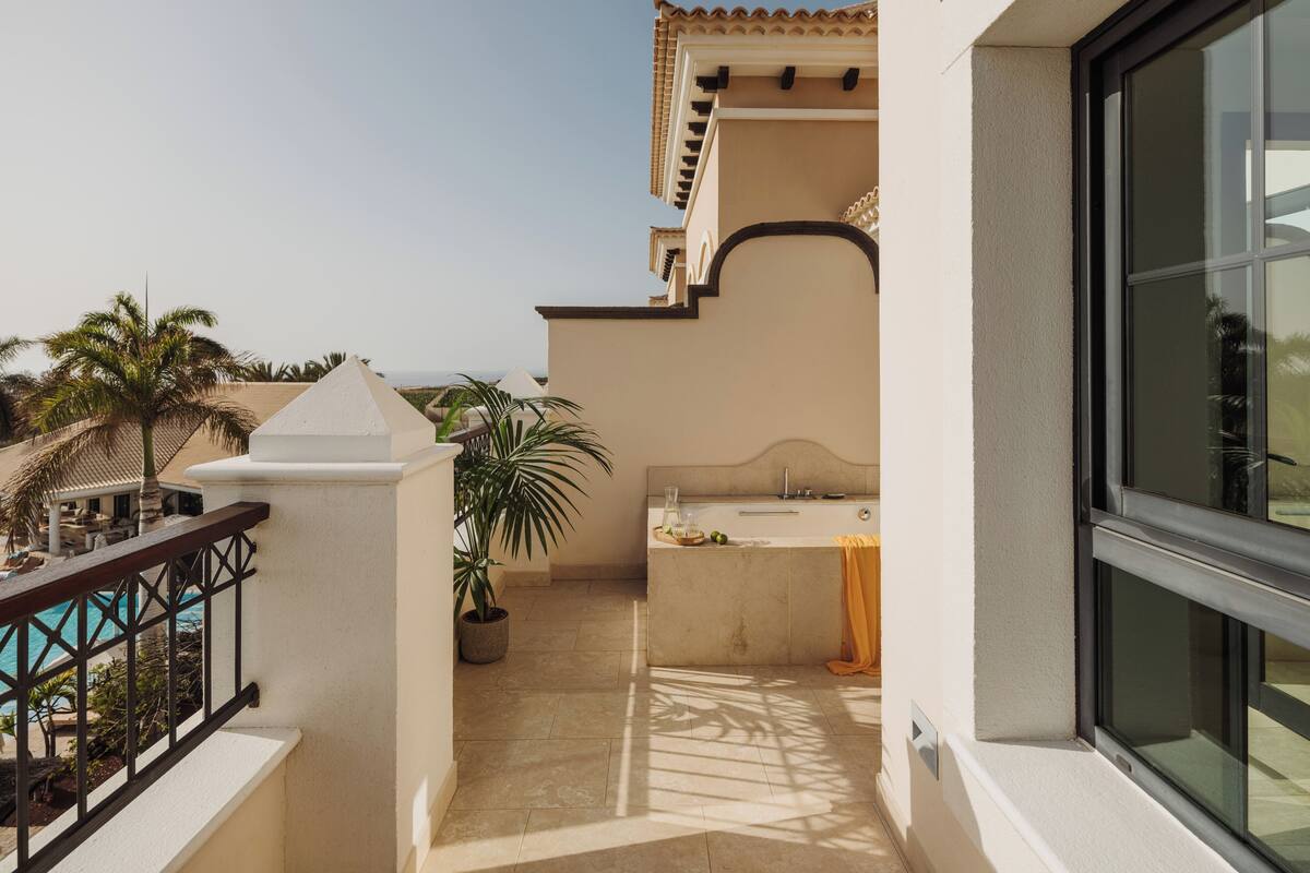 Ein Balkon mit Meerblick, ein Pool und ein Wellnessbereich mit Badewanne und Waschbecken.
