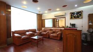 A living room with leather sofas, a glass coffee table, and a wooden cabinet.