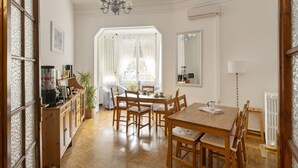 Un coin repas avec des meubles en bois, un lustre et une vue par la fenêtre.