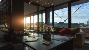 Una sala de estar moderna con un ventanal grande, una mesa de centro, un sofá y una planta en maceta.