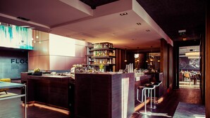 Een moderne barruimte met een centraal bar eiland, barkrukken en flessenkasten.