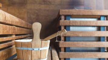 A wooden bucket with a wooden mallet on a bench in a rustic setting.