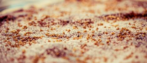 A close-up of a dessert with a crumbly texture and a dusting of powdered sugar.