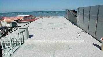 Am Strand, weißer Sandstrand, Liegestühle, Sonnenschirme