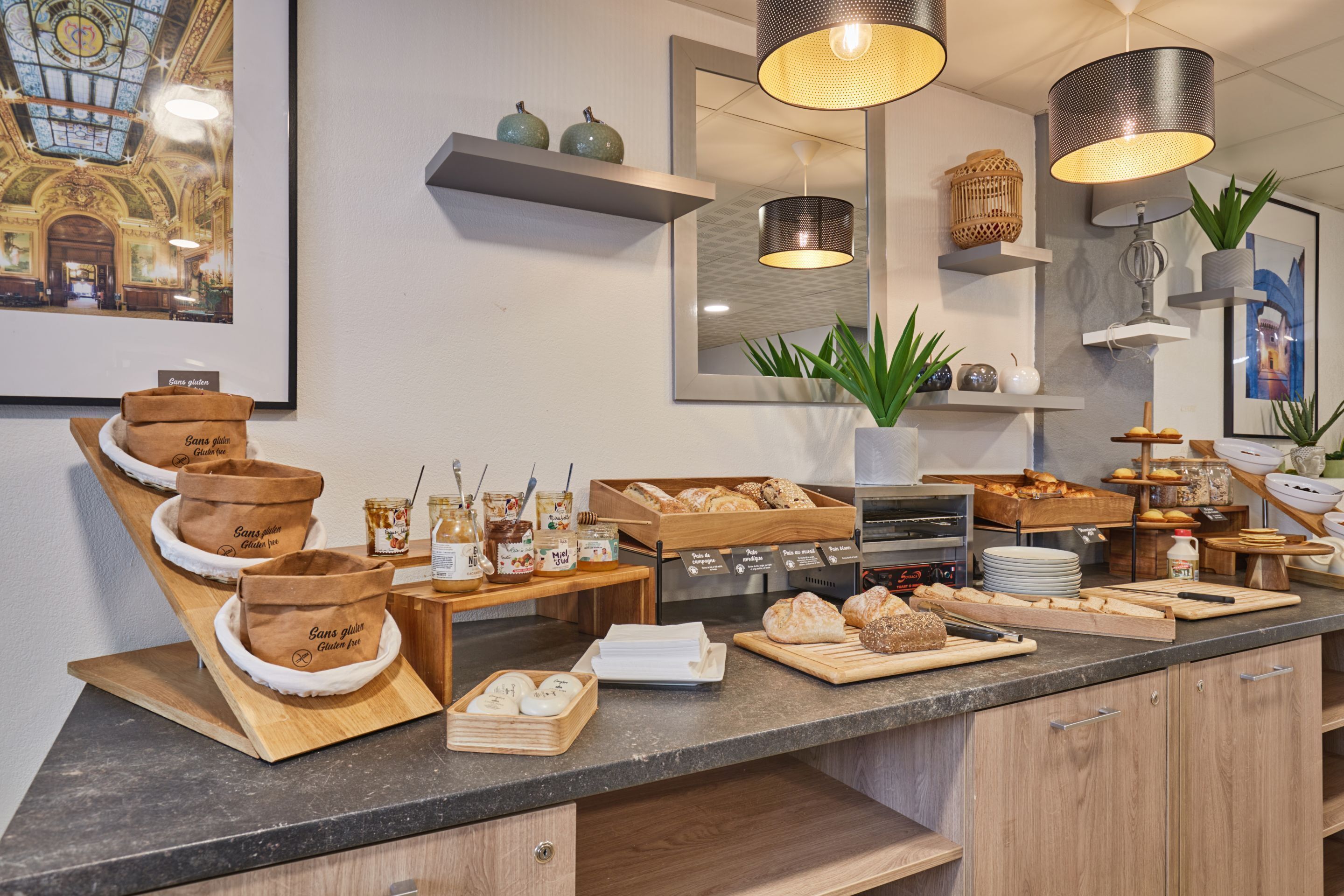 A bakery counter with bread, pastries, and jars of spreads.