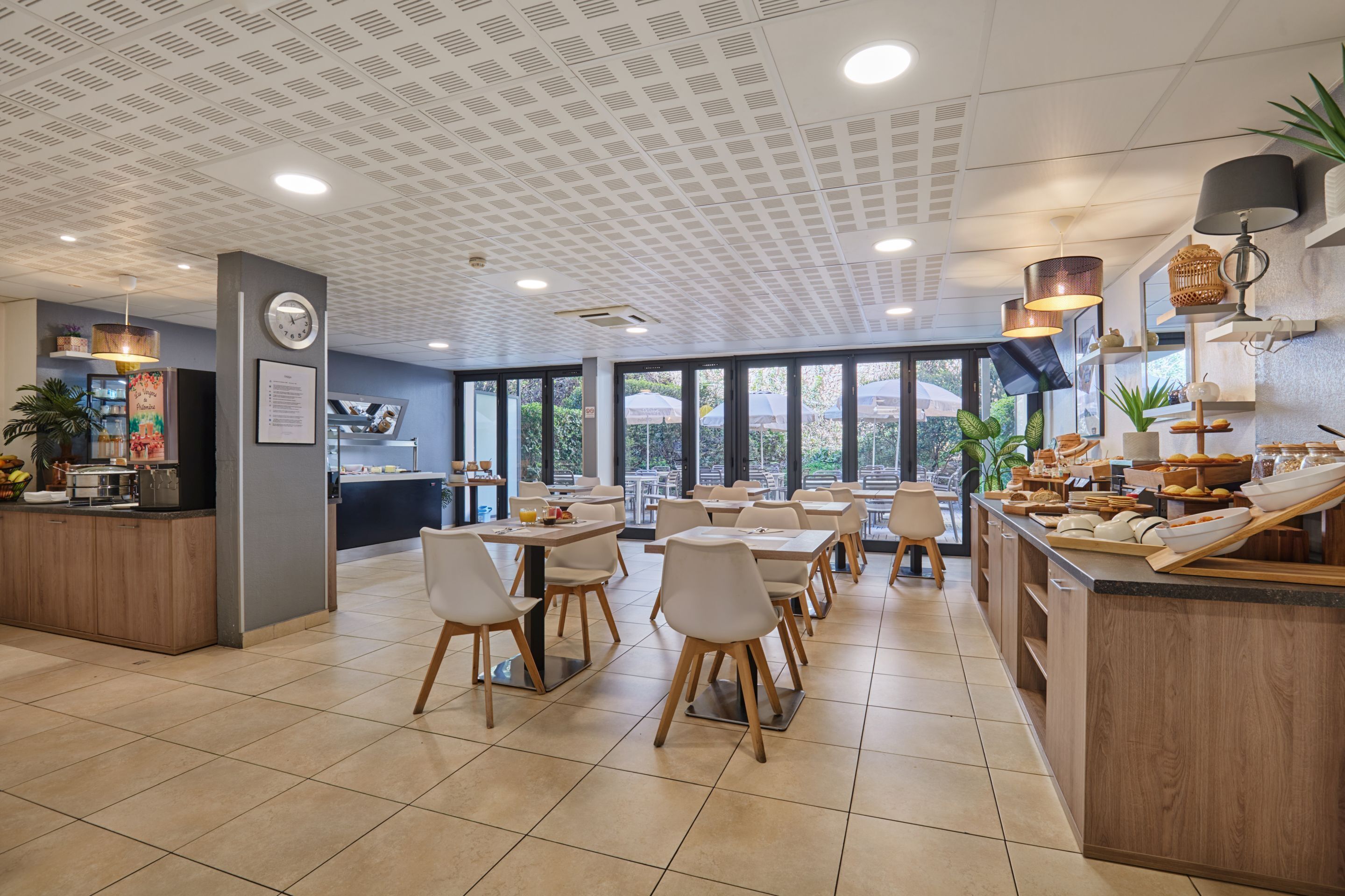 A modern restaurant with a central island, dining tables, and chairs.