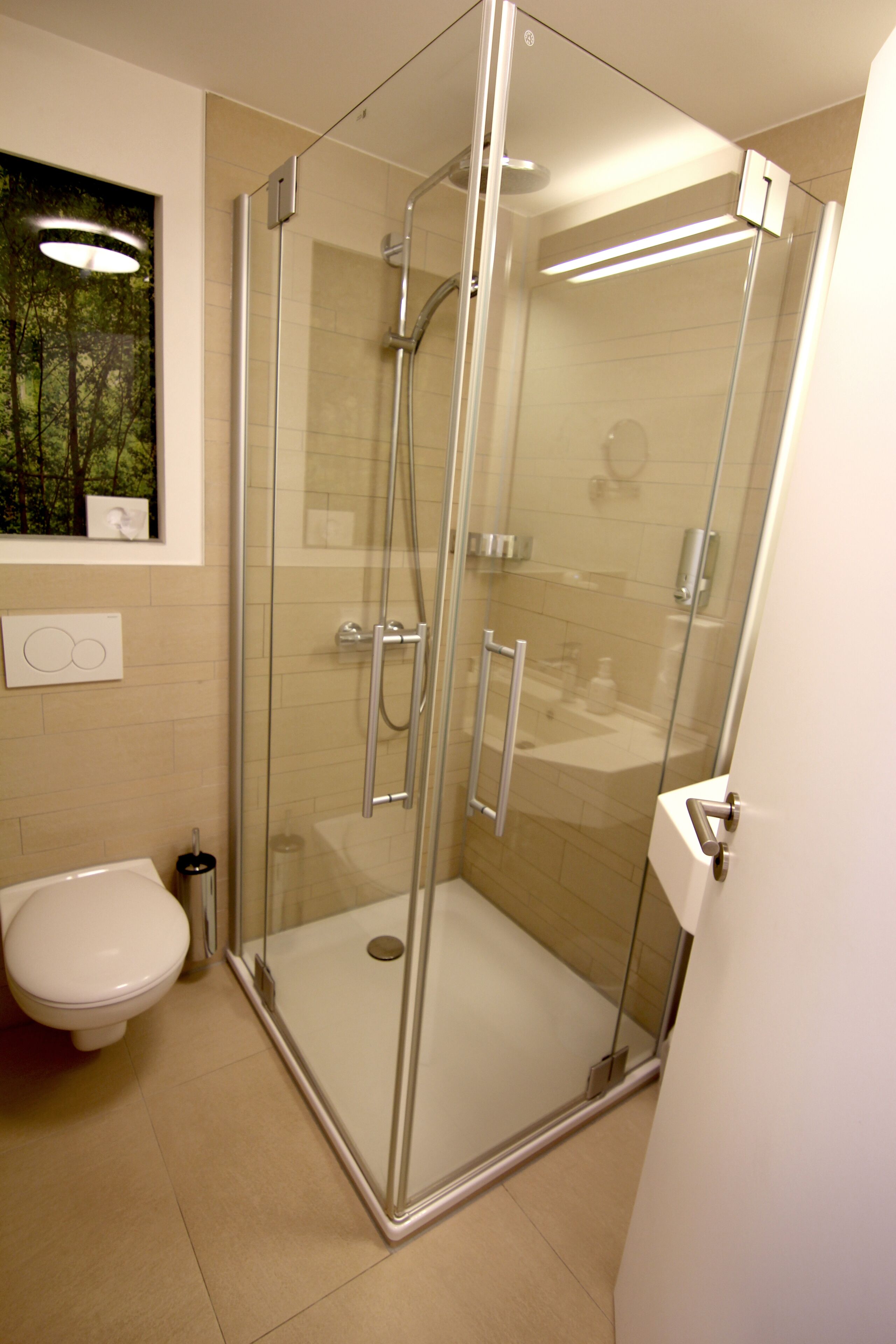 Une salle de bain moderne avec une douche à parois de verre, des toilettes et un lavabo.
