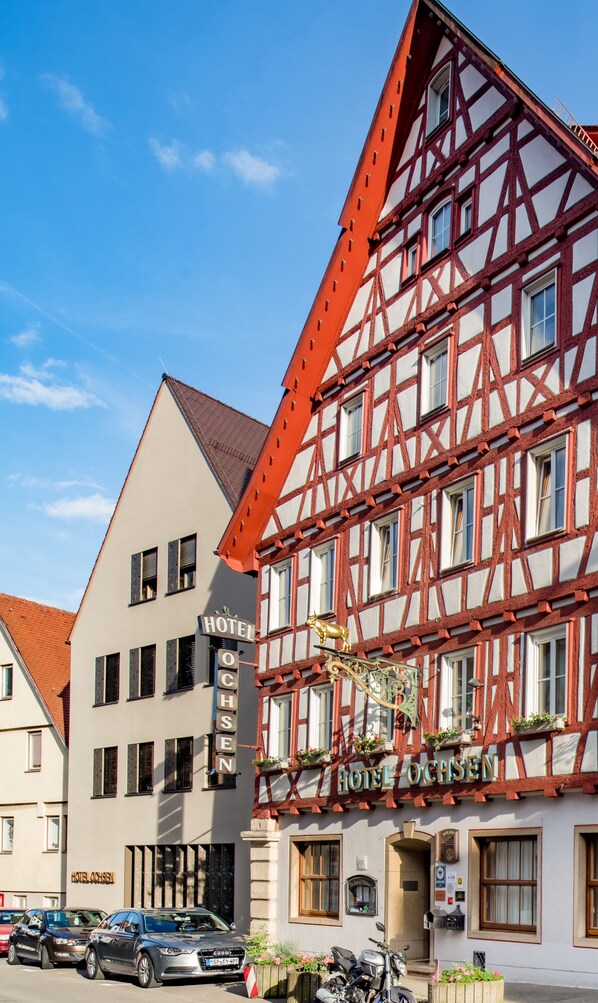 Ein traditionelles Fachwerkhäuschen mit einem Schild, auf dem 'HOTEL OCHSEN' steht.