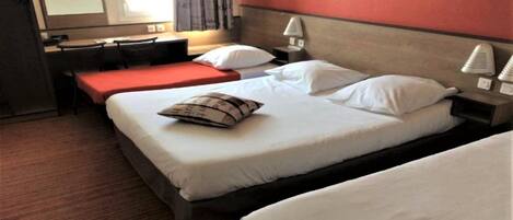A hotel room with two beds, a desk, and a chair.