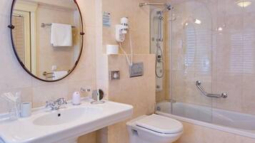 Un bagno moderno con lavabo su piedistallo, WC e cabina doccia in vetro.