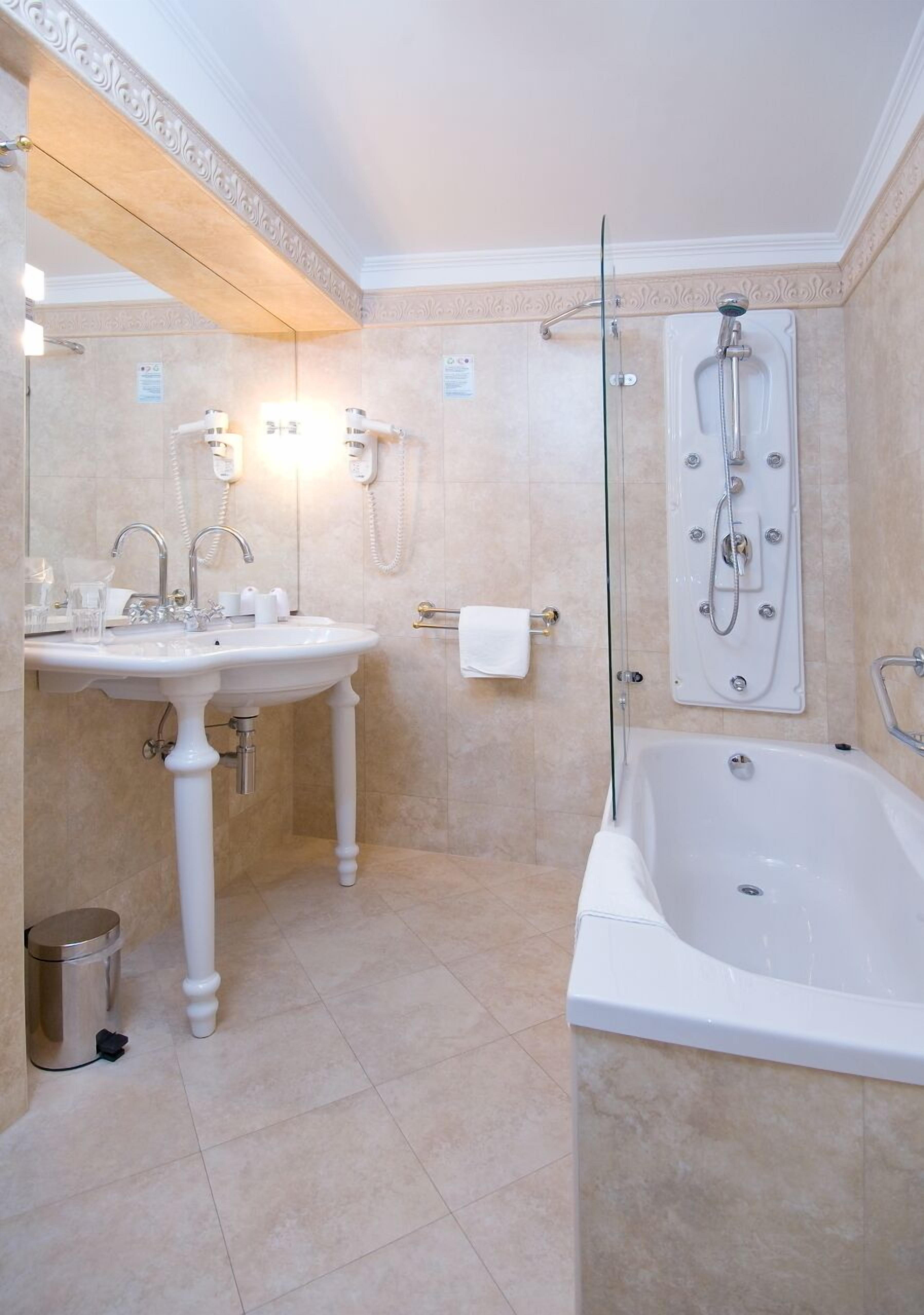 Ein Badezimmer mit einer Badewanne, einem Waschbecken und einer Duschkabine aus Glas.