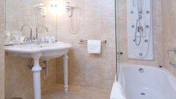 Ein Badezimmer mit einer Badewanne, einem Waschbecken und einer Duschkabine aus Glas.