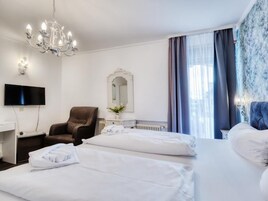 Habitación de hotel con dos camas, un televisor, una silla y una araña.