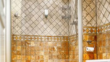 A bathroom with a shower enclosure, a toilet, and a patterned floor.