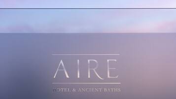 A logo with the text "AIRE HOTEL & ANCIENT BATHS".