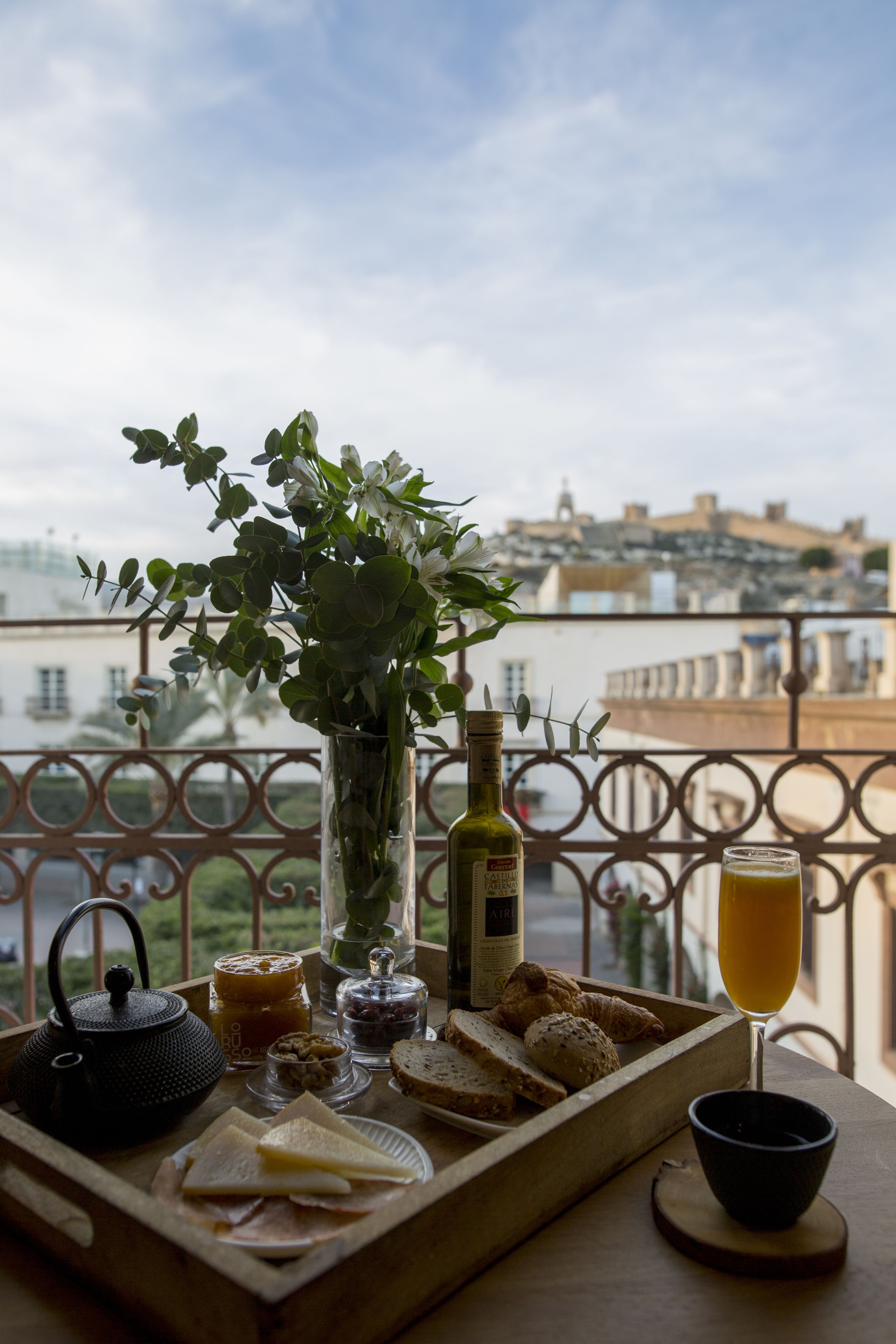 A tray with food and drinks on a balcony overlooking a cityscape.