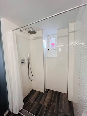 A shower with a handheld showerhead, a glass door, and a small window. - Studio Eleni (Mykonos)