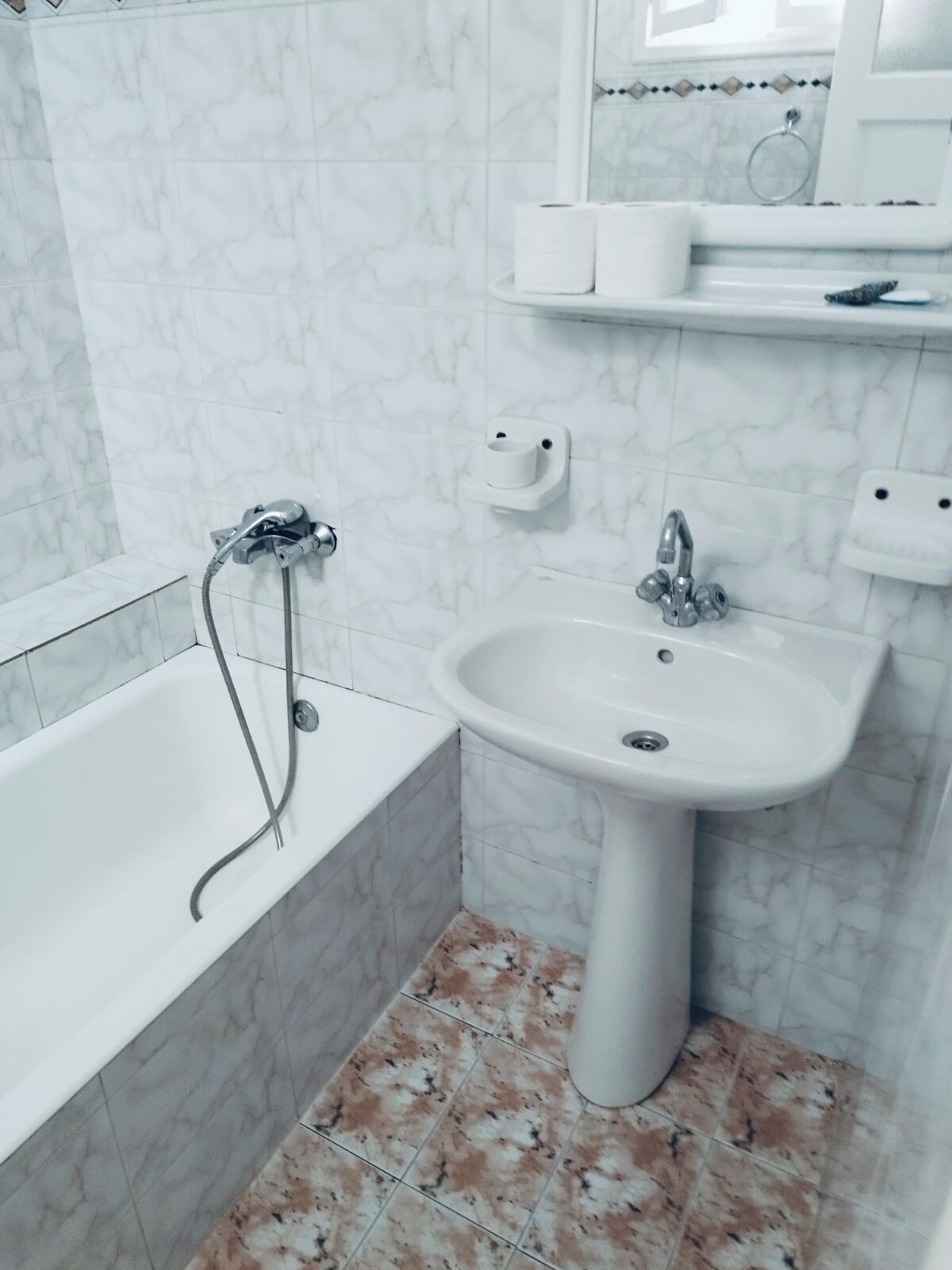 Un baño con bañera, lavamanos y espejo.
