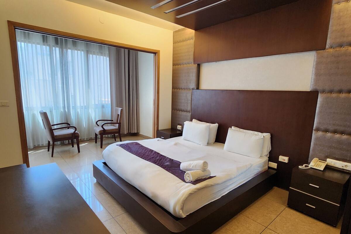 Una habitación de hotel moderna con una cama grande, un escritorio y una silla.
