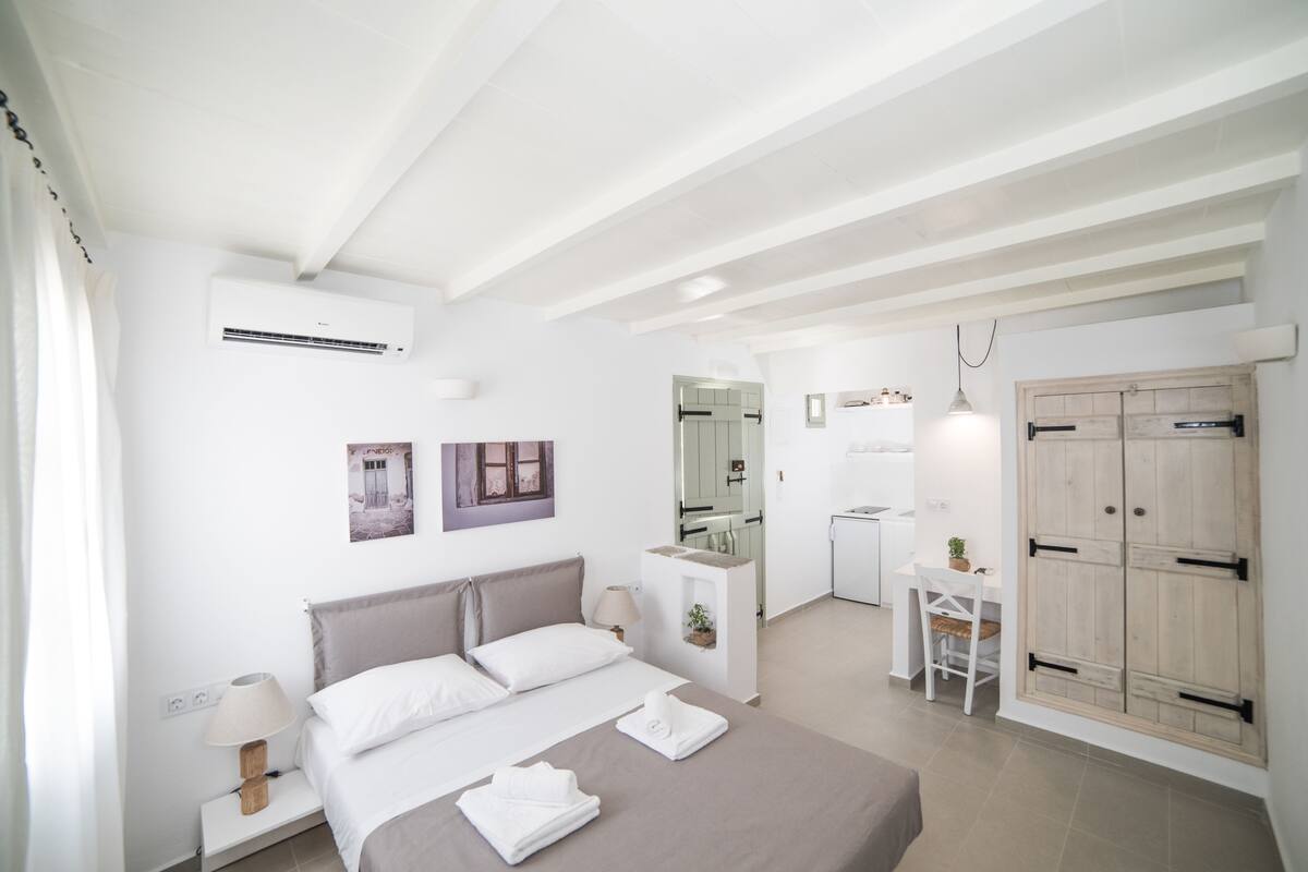 Une chambre moderne avec un lit, une table de chevet et un petit espace bureau.
