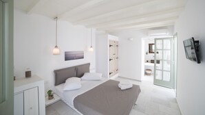 Un dormitorio moderno con cama, mesita de noche y vistas al baño.