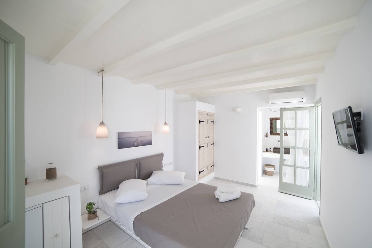Une chambre à coucher moderne avec un lit, une table de chevet et une vue sur la salle de bain.