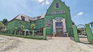 A green building with a sign that reads "BinderBubi HOTEL".